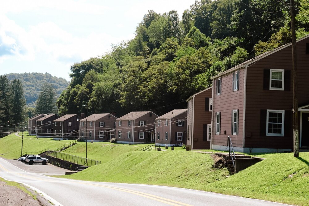 Housing properties aligned along the street with the sky and mountains in the background